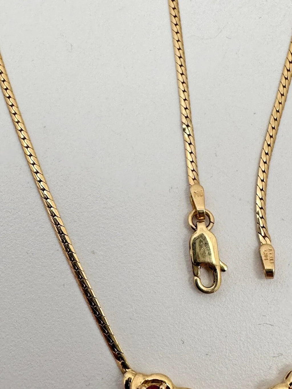 17-inch 14K yellow gold necklace, adorned with 7 oval 4 mm x 6 mm rubies and 3 round diamonds