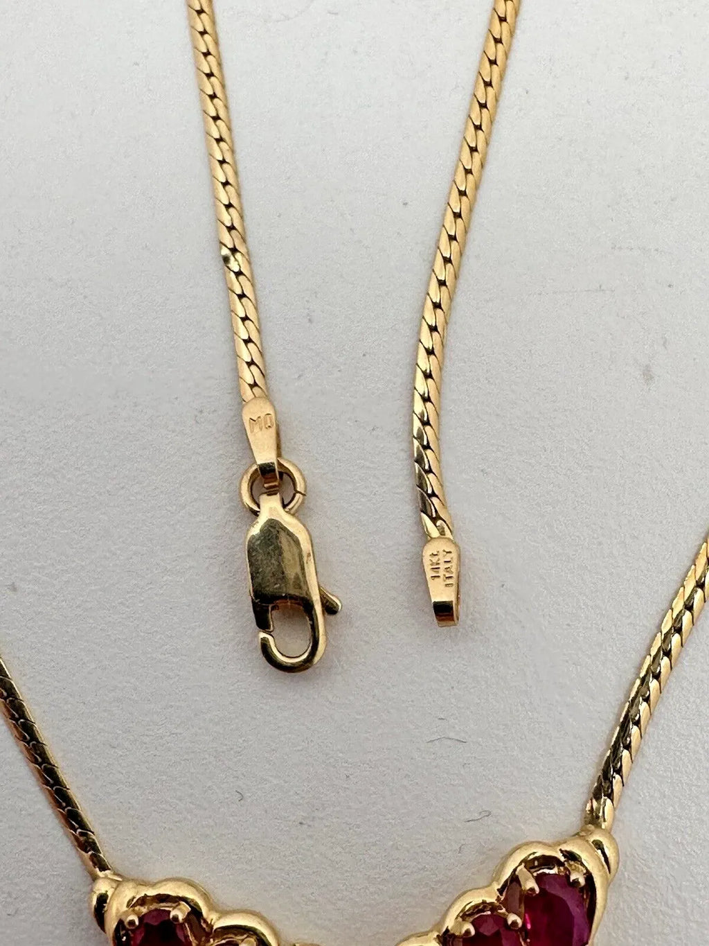 17-inch 14K yellow gold necklace, adorned with 7 oval 4 mm x 6 mm rubies and 3 round diamonds