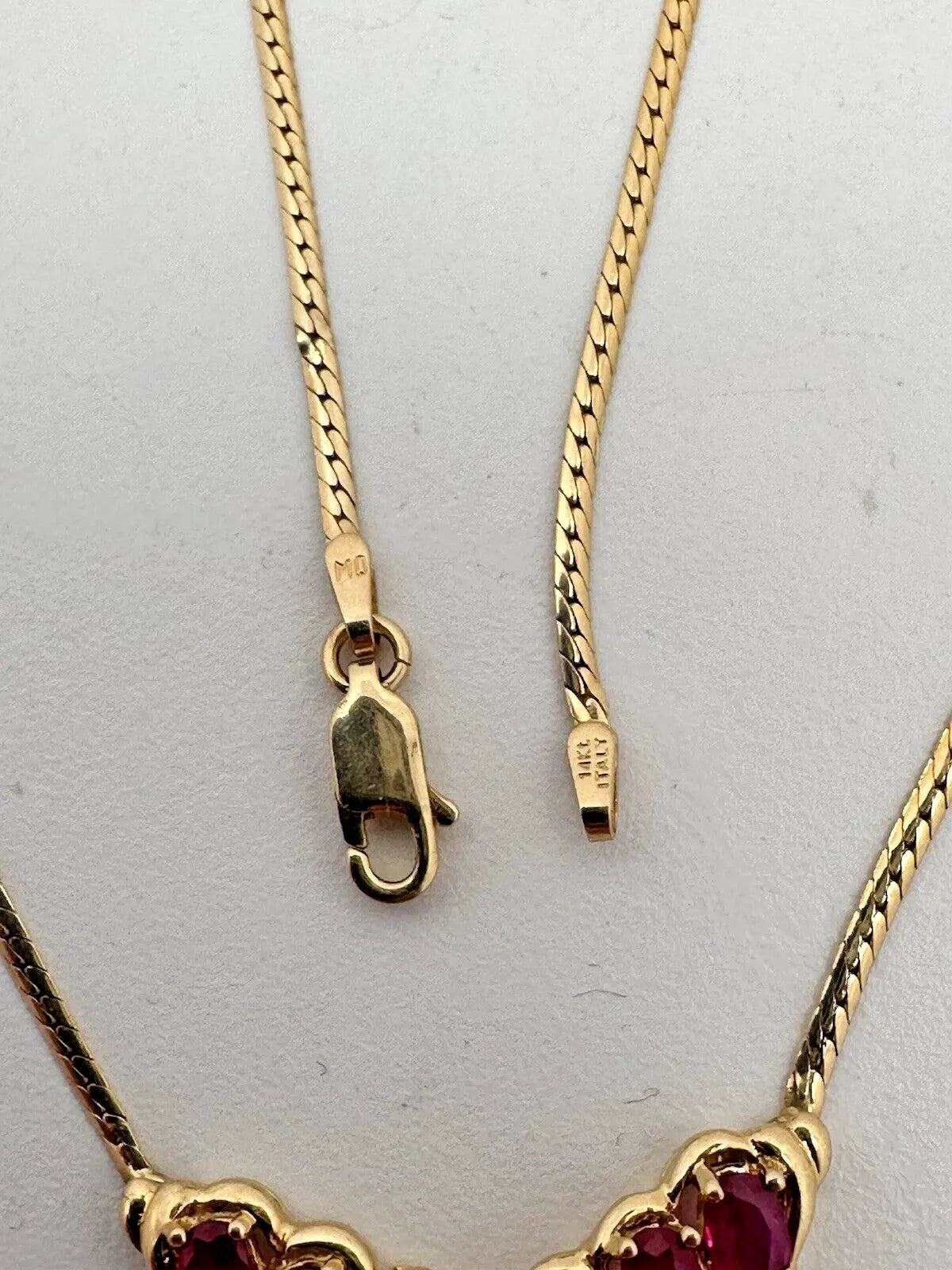 17-inch 14K yellow gold necklace, adorned with 7 oval 4 mm x 6 mm rubies and 3 round diamonds
