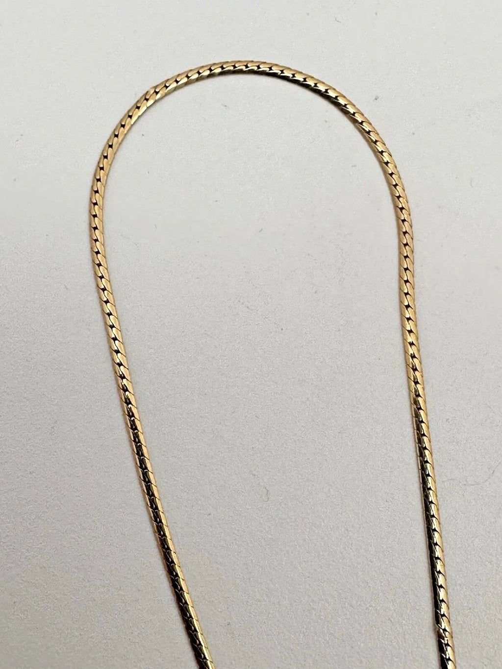 17-inch 14K yellow gold necklace, adorned with 7 oval 4 mm x 6 mm rubies and 3 round diamonds